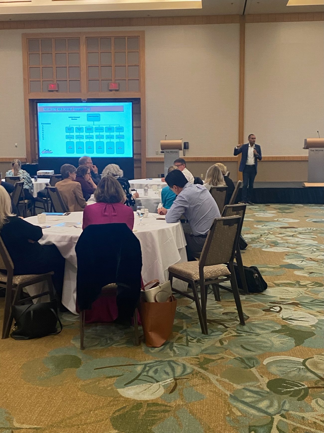 Chris Joffe presenting to attendees seated at rounds
